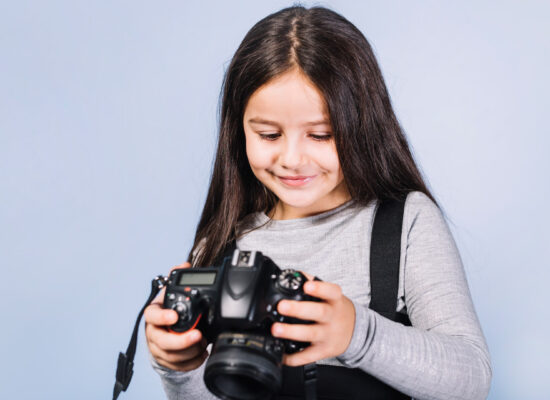 beautiful girl kid playing with camera studio photoshoot